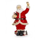 Weihnachtsmann-Figur im Retro-Design mit goldener Glocke, Päckchen im Arm und diversen Geschenken wie Lok, Buch, Spielhaus und Tanne